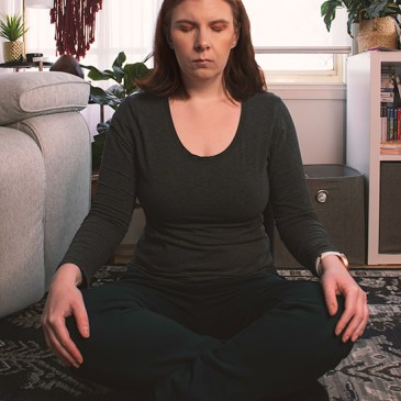 A woman in a sit down meditation pose.