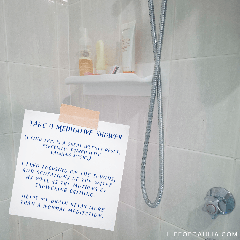 A photo that feature a brightly lit shower room. And a piece of paper in the foreground that talks about having a meditative shower.