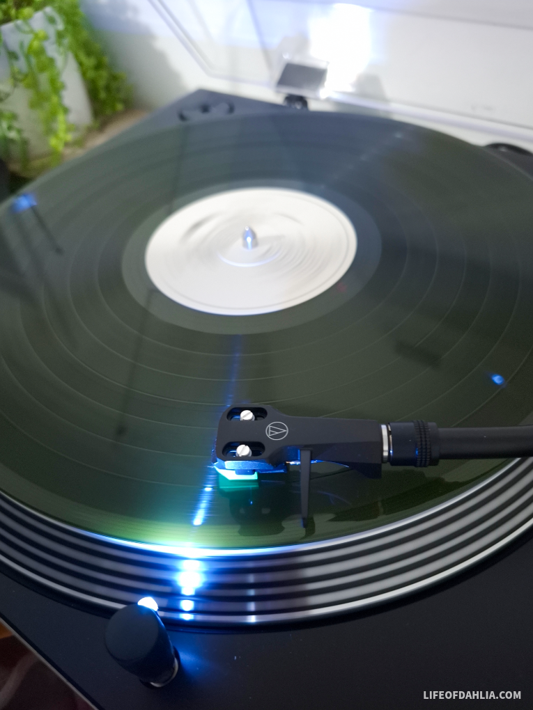A green vinyl record spinning on a record player